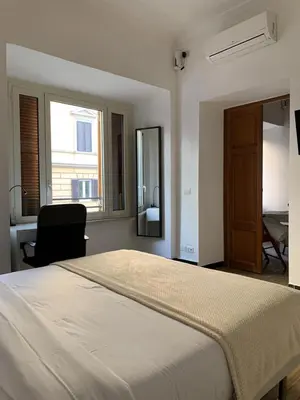a bedroom with a bed and a chair and a window at Flat Between The Vatican and Piazza del Popolo in Rome