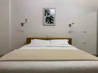 a bedroom with a large bed with white sheets at Flat Between The Vatican and Piazza del Popolo in Rome