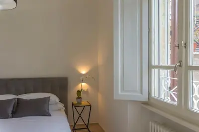 a bedroom with a bed next to a window at Borgo Charme Elegante e Unico. Dimora da Sogno in Rome