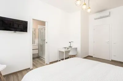 a white bedroom with a bed and a desk at BDC - Euphoria 2BDR at Vatican in Rome