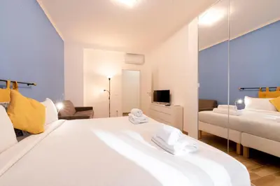 a bedroom with a large white bed and a mirror at BDC - Euphoria 2BDR at Vatican in Rome