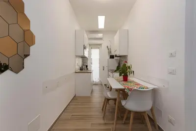 a kitchen with white cabinets and a table and chairs at BDC - Euphoria 2BDR at Vatican in Rome