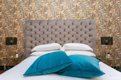 a bed with blue and white pillows on it at Borgo Plauto Oasi di Eleganza vicino al vaticano in Rome