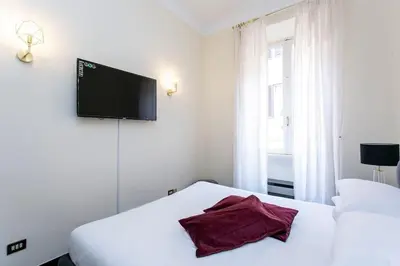 a bedroom with two beds and a flat screen tv at Borgo Plauto Oasi di Eleganza vicino al vaticano in Rome