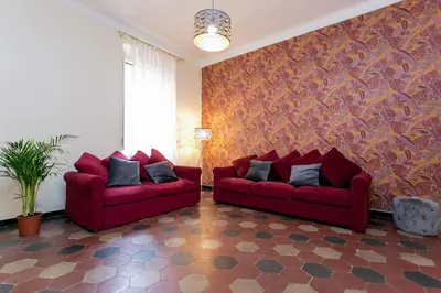 a living room with two red couches and a wall at Borgo Plauto Oasi di Eleganza vicino al vaticano in Rome