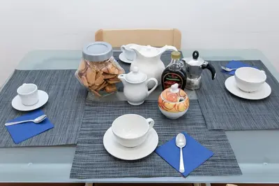 a table with plates and cups and a tea set at Borgo Plauto Oasi di Eleganza vicino al vaticano in Rome