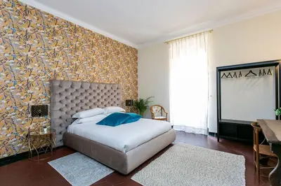 a bedroom with a large white bed and a wall at Borgo Plauto Oasi di Eleganza vicino al vaticano in Rome