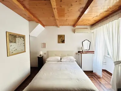 a bedroom with a large bed and a wooden ceiling at B&B Gelsomina Apartment in Rome