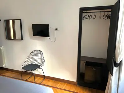 a chair in a room with a television and a mirror at B&B Gelsomina Apartment in Rome