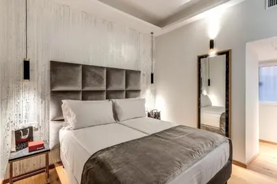 a bedroom with a large bed and a mirror at Goldoni 47 in Rome
