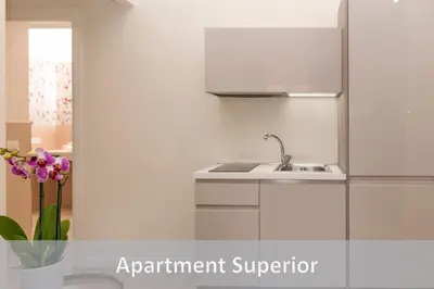 a white kitchen with a sink and a vase of flowers at Best Vatican Apartment in Rome