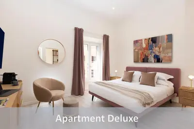 a bedroom with a bed and a chair and a mirror at Best Vatican Apartment in Rome