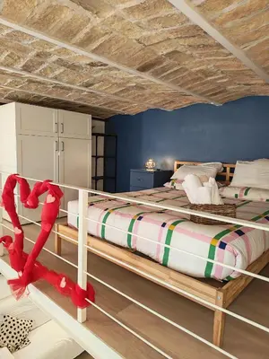 a bedroom with a large bed with red ribbon at Trastevere in Loft Roma in Rome
