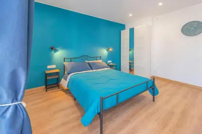 a blue bedroom with a bed and a blue wall at Casetta Tuscolana in Rome