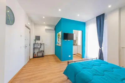 a bedroom with a blue accent wall and a bed at Casetta Tuscolana in Rome