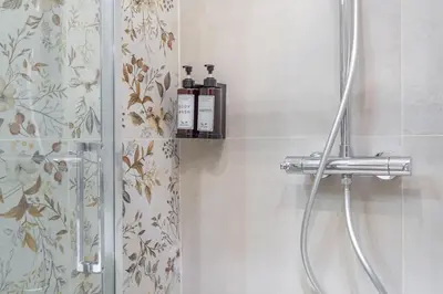 a bathroom with a shower with two bottles on a shelf at Rhome Vatican Rooms in Rome