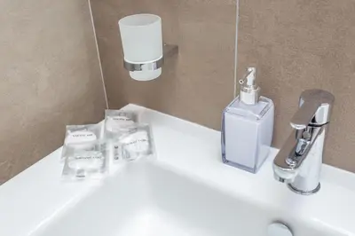 a bathroom sink with a soap dispenser on it at Rhome Vatican Rooms in Rome
