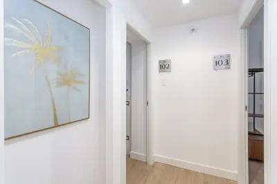 a hallway with a picture of a palm tree on the wall at Rhome Vatican Rooms in Rome
