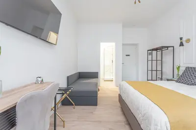 a bedroom with a king sized bed and a desk at Rhome Vatican Rooms in Rome
