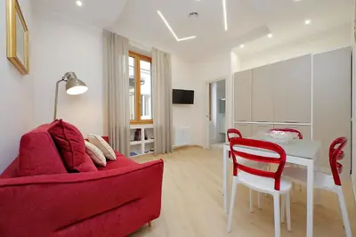 a living room with a red couch and a table at 4BNB - Ottaviano Vatican Flat in Rome