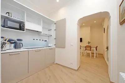 a kitchen with white cabinets and a dining room at 4BNB - Ottaviano Vatican Flat in Rome