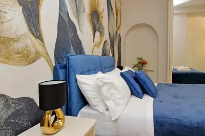 a bedroom with a blue and white bed and a painting at 4BNB - Ottaviano Vatican Flat in Rome