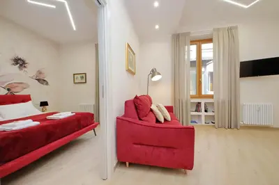 a bedroom with a red couch and a red chair at 4BNB - Ottaviano Vatican Flat in Rome