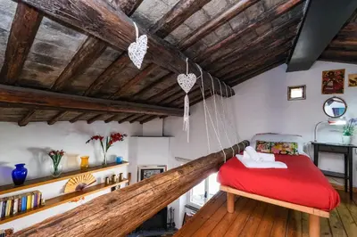 a bedroom with a hammock bed in a room with wooden ceilings at Trastevere Characteristic Roman Home in Rome