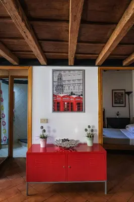 a red table in a room with a bedroom at Trastevere Characteristic Roman Home in Rome