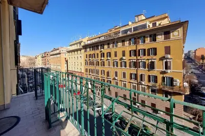 a balcony with a green railing and a building at Etruria At San Giovanni by Halldis in Rome