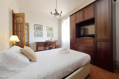 a bedroom with a large white bed and a television at Etruria At San Giovanni by Halldis in Rome
