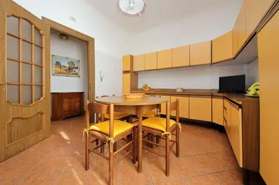 a kitchen with a table and chairs in a room at Etruria At San Giovanni by Halldis in Rome