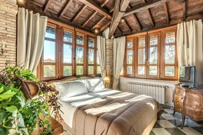 a bedroom with a bed in a room with windows at Villa Alberici in Rome