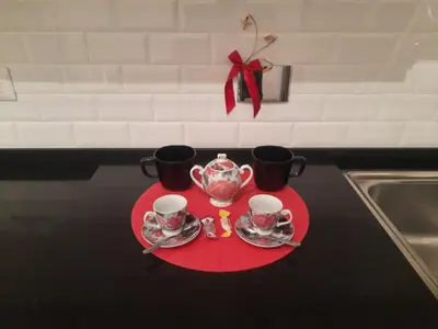 a red plate with two cups and a tea set on it at Delizioso appartamento al Pigneto in Rome