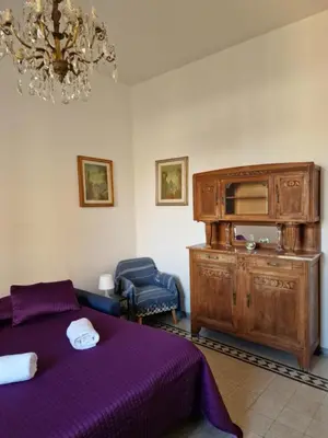 a bedroom with a purple bed and a chandelier at Delizioso appartamento al Pigneto in Rome