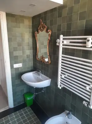 a bathroom with a sink and a mirror and a toilet at Delizioso appartamento al Pigneto in Rome