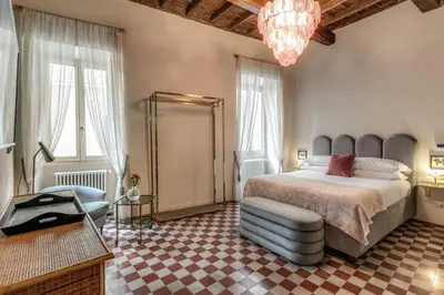 a bedroom with a large bed and a chandelier at Residenza Brama - Art ApartHotel in Rome