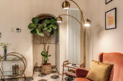 a living room with a chair and a plant at Residenza Brama - Art ApartHotel in Rome