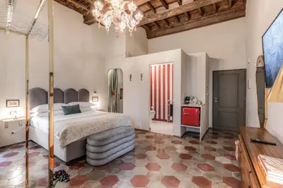 a bedroom with a large bed and a chandelier at Residenza Brama - Art ApartHotel in Rome