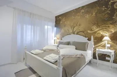 a white bed in a room with a wall at Conny's Home in Rome