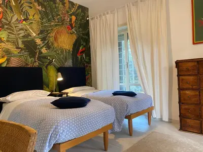 two beds in a room with a painting on the wall at Conny's Home in Rome
