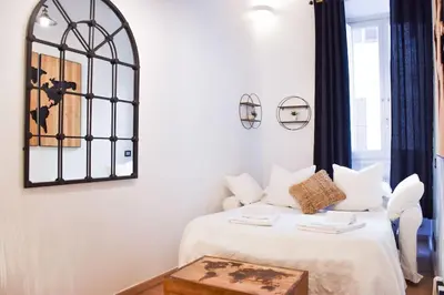 a bedroom with a bed with white sheets and a table at Spanish Steps-Trevi -Luma Suite in Rome
