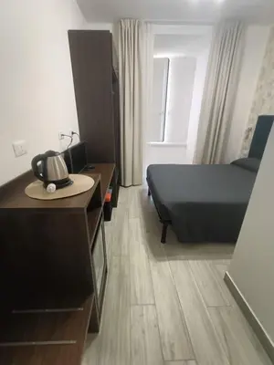 a small room with a bed and a desk and a bed sqor at Nives House Roma in Rome