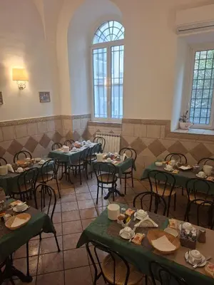 a room with tables and chairs with food on them at Nives House Roma in Rome