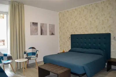 a bedroom with a blue bed and a chair at Nives House Roma in Rome