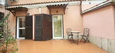 a patio with two chairs and a table in front of a building at La Casetta con giardino al Pigneto in Rome