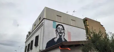 a building with a painting of a man on the side of it at La Casetta con giardino al Pigneto in Rome