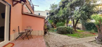 a patio with a table and chairs next to a building at La Casetta con giardino al Pigneto in Rome