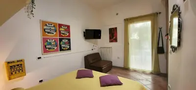 a bedroom with a bed and a chair and a window at La Casetta con giardino al Pigneto in Rome