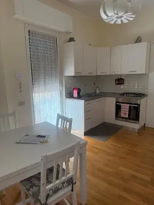 a kitchen with white cabinets and a table and chairs at Mon-Tis Paolo V - vicino metro Cornelia in Rome